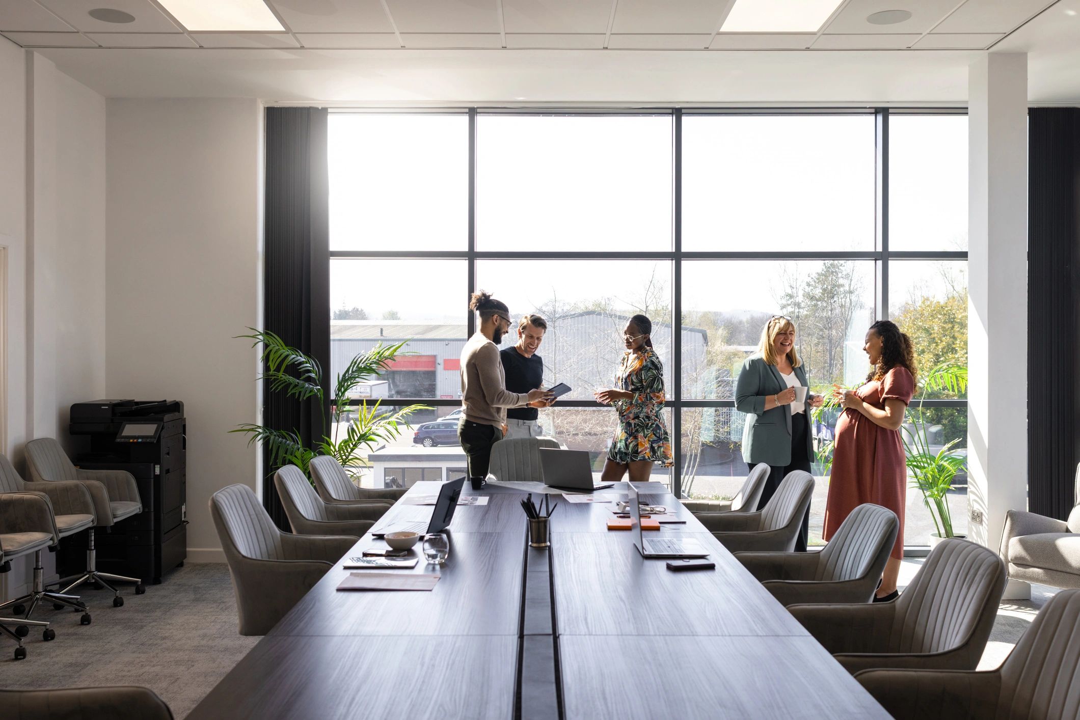 Business colleagues discussing technology plans in a bright conference room